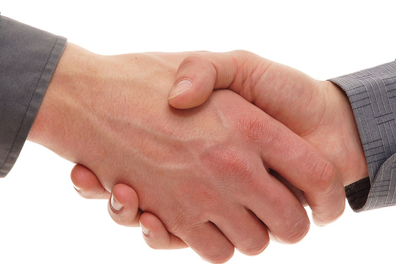 Zwei Personen geben sich die Hand.